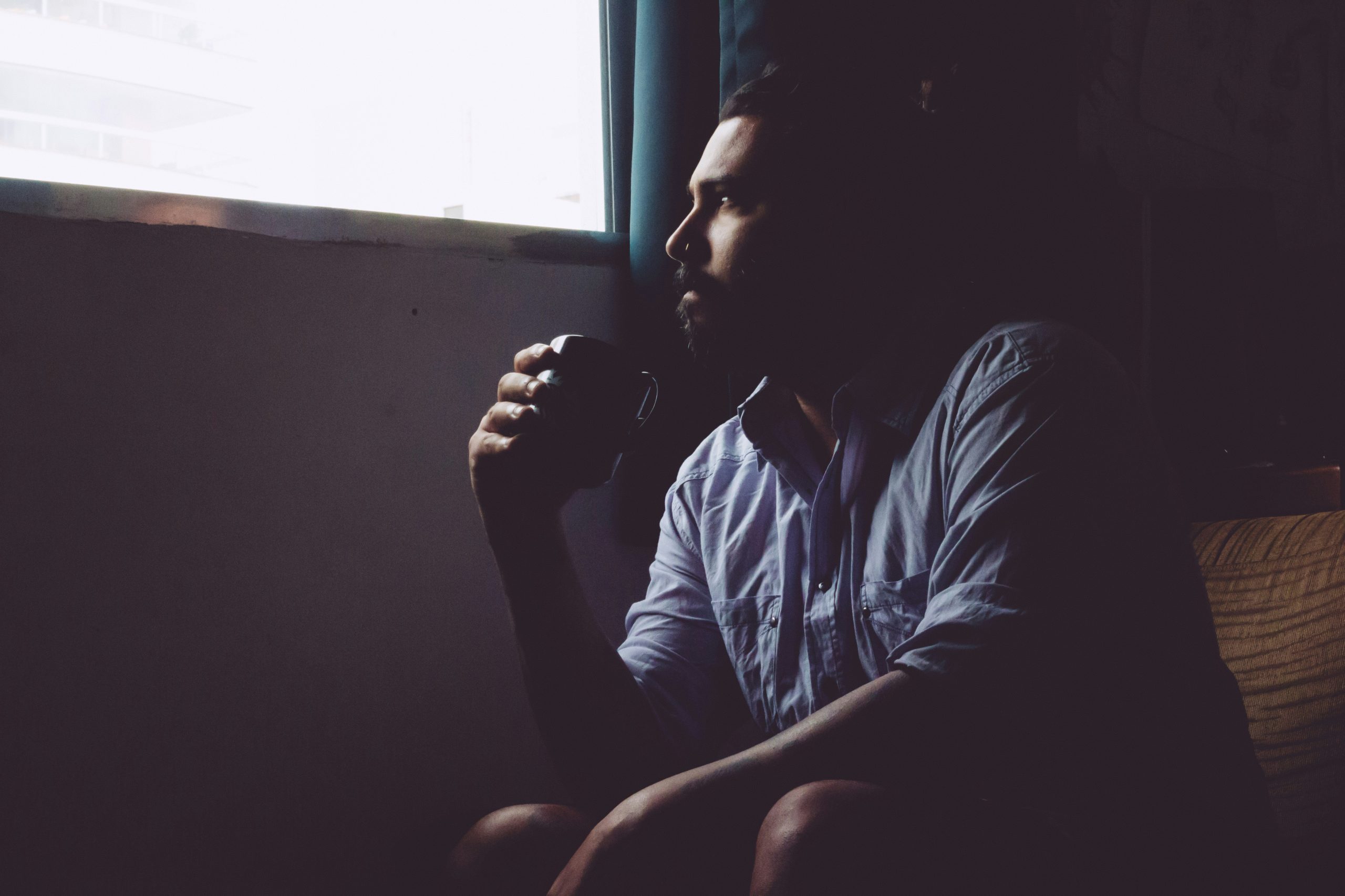 Man drinking coffee, looking reflective